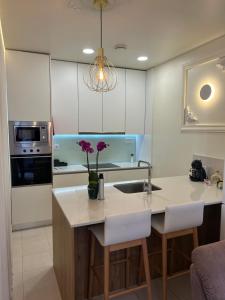 a kitchen with a sink and a counter with purple flowers on it at Boavista Apartments in Paredes de Coura