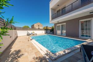a swimming pool in the backyard of a house at Villa Ursula in Pakoštane