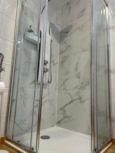 a shower stall with a glass door in a bathroom at Boavista Apartments in Paredes de Coura