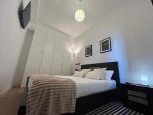 a bedroom with a large bed with white walls at Boavista Apartments in Paredes de Coura
