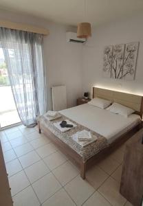 a bedroom with a bed and a large window at Holiday & Business Furnished Apartments in Mytikas