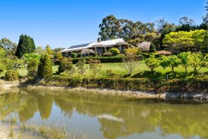 a house on a hill next to a river at Tiverton in Kurrajong