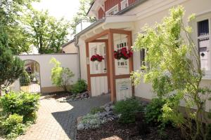 eine Haustür eines Hauses mit Blumen darauf in der Unterkunft Hotel & Café Strandeck in Prerow