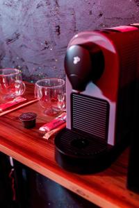 a toaster sitting on top of a wooden table with glasses at Love & Jacuzzi in Bucharest