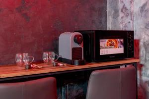 a microwave sitting on top of a table with glasses at Love & Jacuzzi in Bucharest