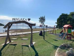a playground at the beach with a swing at Dalmacia Idyll mobilházak Privlaka in Privlaka