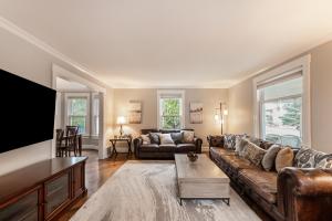 a living room with a couch and a flat screen tv at Steps to Dtwn Plymouth! Home w/ Dog-Friendly Yard in Plymouth