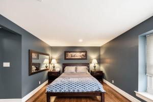 a bedroom with gray walls and a bed and a mirror at Steps to Dtwn Plymouth! Home w/ Dog-Friendly Yard in Plymouth