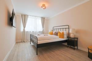 a bedroom with a bed with yellow pillows and a window at KasselRooms Comfort Studio in Kassel
