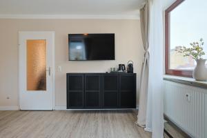 a living room with a black cabinet and a television at KasselRooms Comfort Studio in Kassel +82 photos