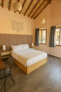 a bedroom with a bed and a table and a chair at Bambu Villas Wellness Center in Amatlán