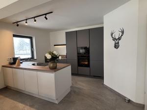 a kitchen with a counter with a deer head on the wall at Sportchalet Bergkristall regio Nassfeld Presseggersee in Kirchbach