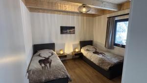 a bedroom with two beds with a deer on the bedspread at Sportchalet Bergkristall regio Nassfeld Presseggersee in Kirchbach +41 photos