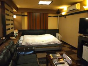 a living room with a bed and a couch at ホテルスター in Iwaki