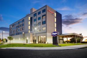 a hotel building with a sign in front of it at Hampton By Hilton Guanacaste Airport in Liberia