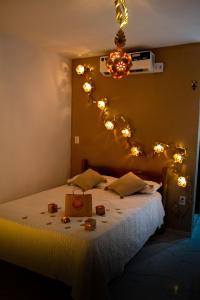 a bedroom with a bed with lights on the wall at SP Hospedagem Canoa Quebrada in Canoa Quebrada