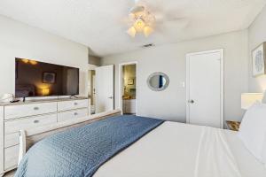 a bedroom with a bed and a tv at Beach Club: The Lighthouse in Padre Island +16 photos