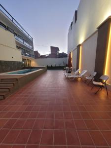a building with a patio with chairs and a pool at Refugio del Turista in Tupiza
