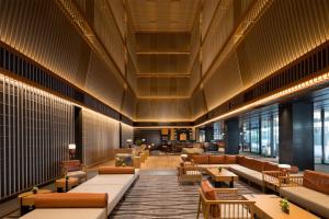 a lobby with couches and tables in a building at Hilton Kyoto in Kyoto