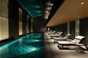a swimming pool with lounge chairs and a hotel room at Hilton Kyoto in Kyoto