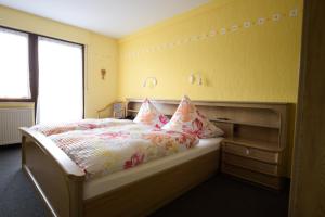 a bedroom with a bed with a dresser and a window at Landgasthaus Pension Schmidthöfer in Berschweiler