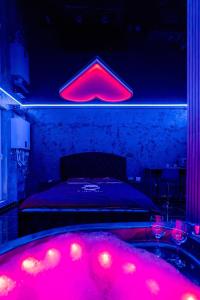 a bedroom with a bed with red lights on it at Love & Jacuzzi in Bucharest
