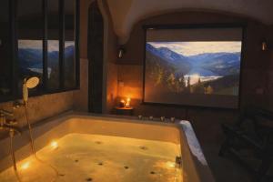 a bath tub in a bathroom with a view of mountains at Les Voûtes Secrètes - Love Room avec Balnéo à Bras in Bras