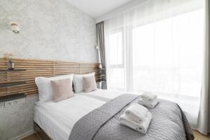 a bedroom with a large bed with towels on it at City Break Śląska 8 by INA in Gdańsk