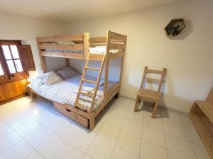 a bedroom with bunk beds with a ladder and a chair at Ca la iaia - Turisme familiar in Amer