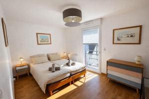a bedroom with a large bed and a window at Le Clos Savignac in Trouville-sur-Mer