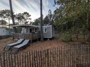 a tiny house with a deck and a gazebo at Bungalow mahi-mahi in Lacanau