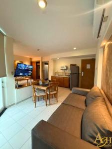 a living room with a couch and a table and a kitchen at Angeles Suites & Hotel in Veracruz