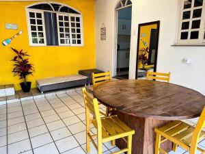 a table and chairs in a room with a yellow wall at Quarto 1 econômico Centro Itajaí in Itajaí