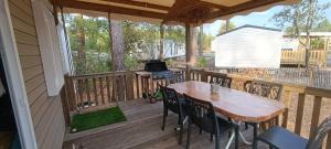 a porch with a table and chairs on a deck at Bungalow mahi-mahi in Lacanau