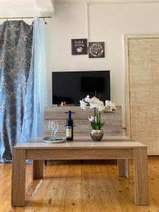 a wooden coffee table with a bottle of wine on it at Themis Apartment in Kotor