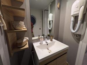 a bathroom with a sink and a mirror at Bungalow mahi-mahi in Lacanau
