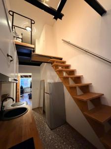a staircase in a room with a kitchen and a refrigerator at Loft in Viljandi Old Town in Viljandi