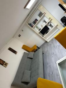 a living room with a gray couch and a yellow chair at Appartement familial de 60 M2 in Angoulême