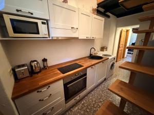 a kitchen with white cabinets and a microwave at Loft in Viljandi Old Town in Viljandi