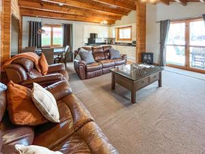 a living room with leather couches and a coffee table at Avocet Lodge in Horncastle