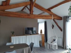a dining room with a table and a hanging chair at La Cabane aux Hirondelles in Entraigues