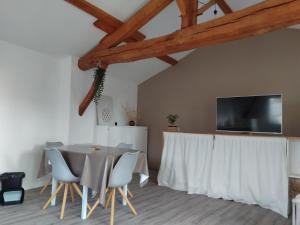 a dining room with a table and chairs at La Cabane aux Hirondelles in Entraigues