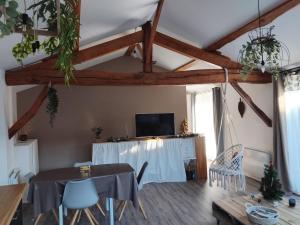 a living room with a table and a tv at La Cabane aux Hirondelles in Entraigues