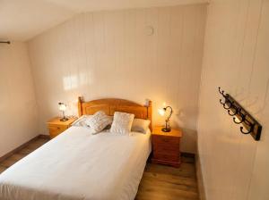 ein Schlafzimmer mit einem Bett mit weißer Bettwäsche und zwei Lampen in der Unterkunft Casa El Pedernal in Basardilla + 21 Fotos