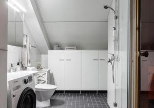 a white bathroom with a toilet and a sink at Modern Two-Bedroom Apartment with Sauna & Free Parking in Turku