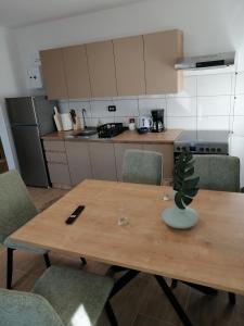 a kitchen with a wooden table with chairs and a plant on it at Apartman Antonio 2 in Karlovac