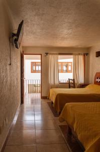 ein Hotelzimmer mit drei Betten und zwei Fenstern in der Unterkunft Hotel Morada de Paz in Colorines