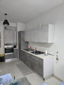 a kitchen with white and gray cabinets and a stove at Casa Roncalli 19-A in Foligno +12 photos