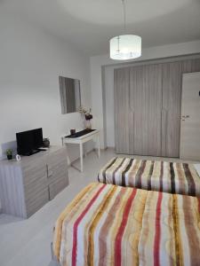 a bedroom with a bed and a dresser and a tv at Casa Roncalli 19-A in Foligno