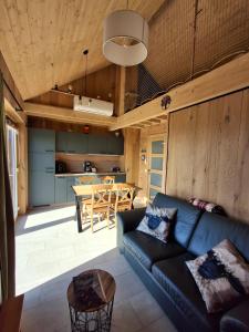 a living room with a couch and a table at Chalet charme et bien-être Jacuzzi et nature près de Durbuy in Durbuy